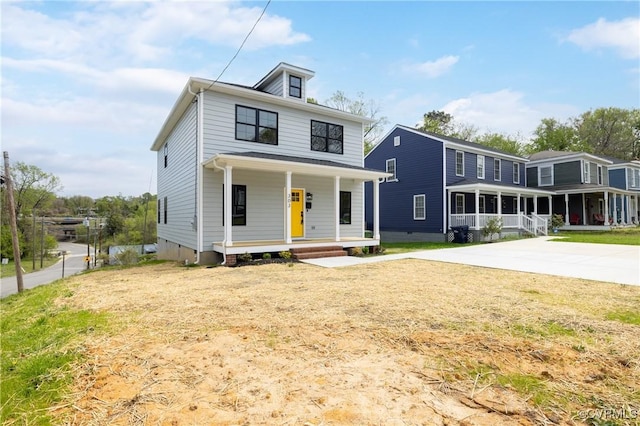 american foursquare style home featuring a porch and a front yard