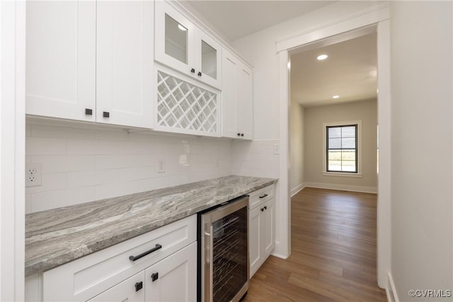 bar featuring wood finished floors, a dry bar, backsplash, wine cooler, and recessed lighting