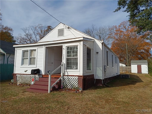 3057 Maury St, Richmond, VA 23224 - view of front of property featuring an outbuilding, a shed, entry steps, fence, and a front lawn
