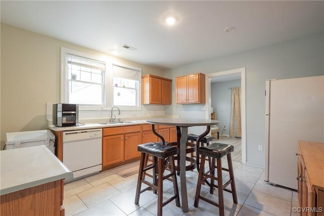 3057 Maury St, Richmond, VA 23224 - kitchen with white appliances, light tile patterned floors, light countertops, visible vents, and a sink