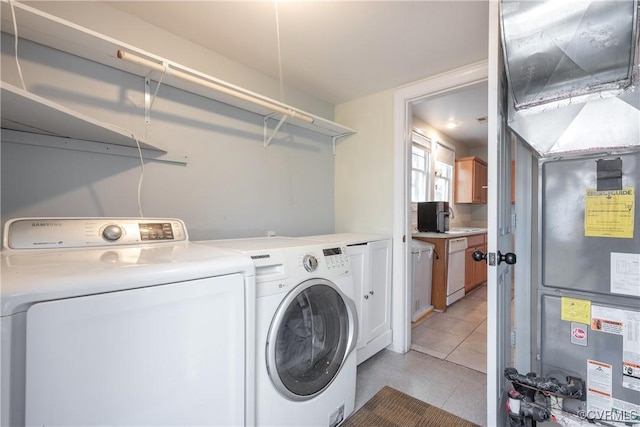 3057 Maury St, Richmond, VA 23224 - laundry area with washer and dryer, light tile patterned floors, and cabinet space