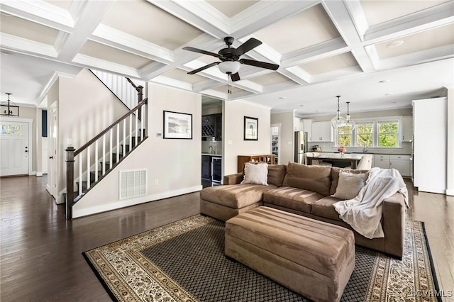 living area featuring visible vents, coffered ceiling, a ceiling fan, crown molding, and dark wood-type flooring