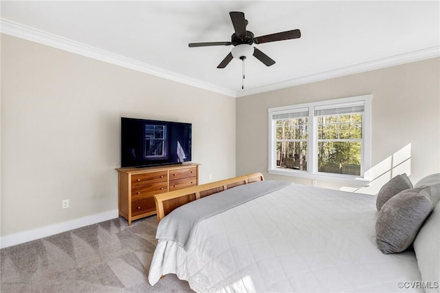 carpeted bedroom with a ceiling fan, baseboards, and crown molding