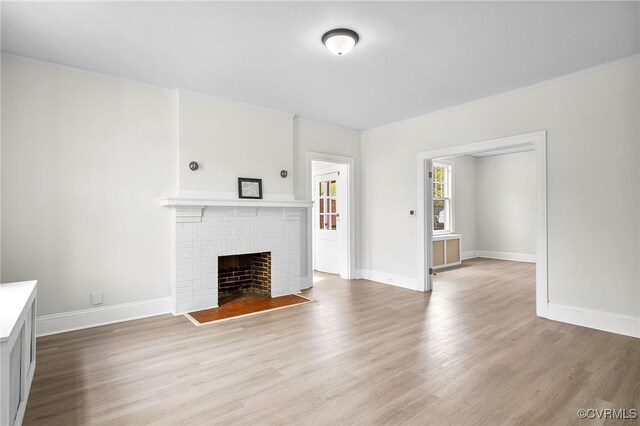 2407 Dumbarton Rd, Henrico, VA 23228 - unfurnished living room with light wood-type flooring, a brick fireplace, and ornamental molding