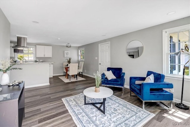 living area with baseboards and wood finished floors