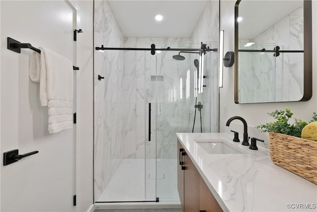 full bathroom with vanity, a marble finish shower, and recessed lighting