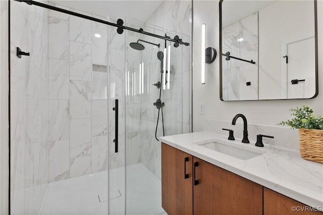 full bathroom featuring vanity and a marble finish shower