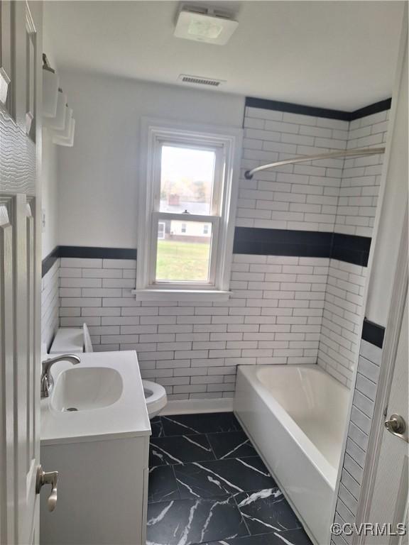 410 N Daisy Ave, Henrico, VA 23075 - full bathroom with marble look tiles, vanity, toilet, wainscoting, and tile walls