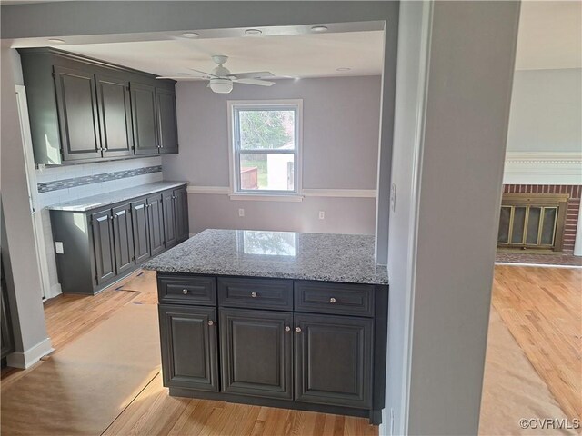 410 N Daisy Ave, Henrico, VA 23075 - kitchen featuring tasteful backsplash, ceiling fan, light stone counters, light wood-style flooring, and dark cabinets
