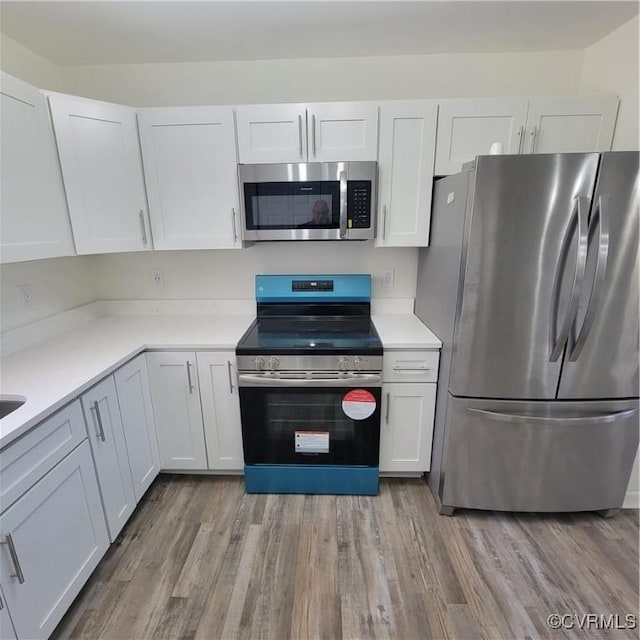19164 Woodsons Mill Rd, Beaverdam, VA 23015 - kitchen featuring white cabinets, light countertops, appliances with stainless steel finishes, and light wood-type flooring