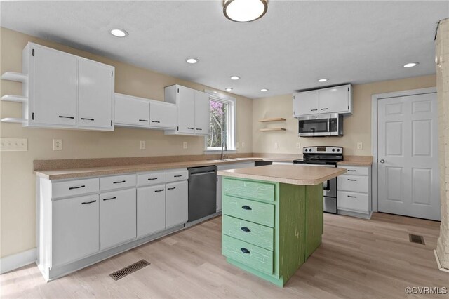 1413 First Rock Rd, Prospect, VA 23960 - kitchen featuring open shelves, appliances with stainless steel finishes, light countertops, white cabinetry, and visible vents