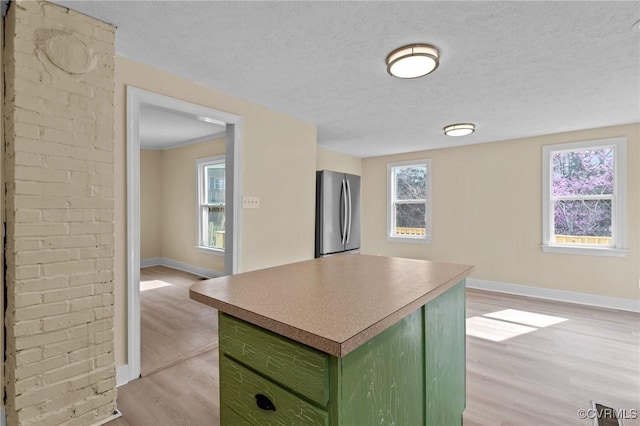 1413 First Rock Rd, Prospect, VA 23960 - kitchen featuring green cabinetry, light wood finished floors, freestanding refrigerator, baseboards, and a kitchen island