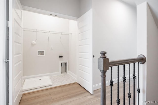 clothes washing area with light wood-style flooring, laundry area, baseboards, and hookup for a washing machine