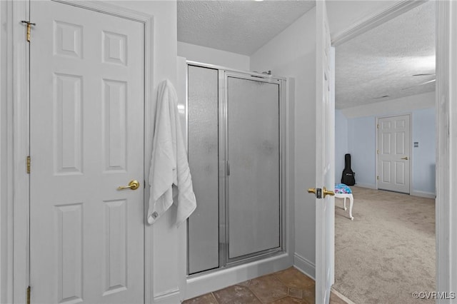 full bathroom with baseboards, a shower stall, and a textured ceiling