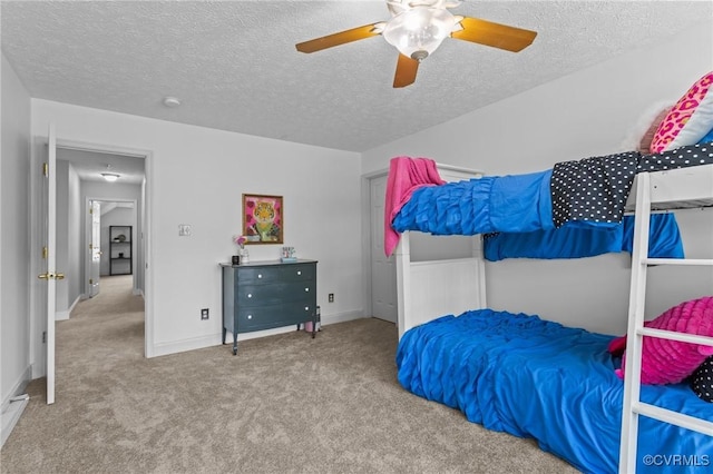 bedroom featuring a textured ceiling, a ceiling fan, carpet floors, and baseboards