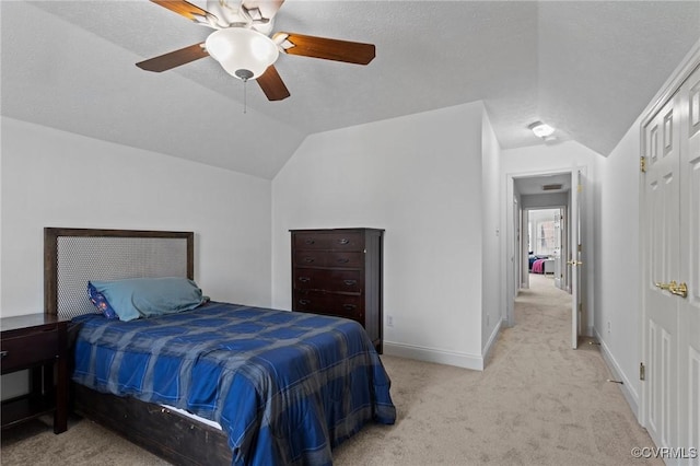 bedroom featuring ceiling fan, light carpet, lofted ceiling, and baseboards