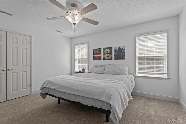 carpeted bedroom with baseboards, visible vents, and a textured ceiling