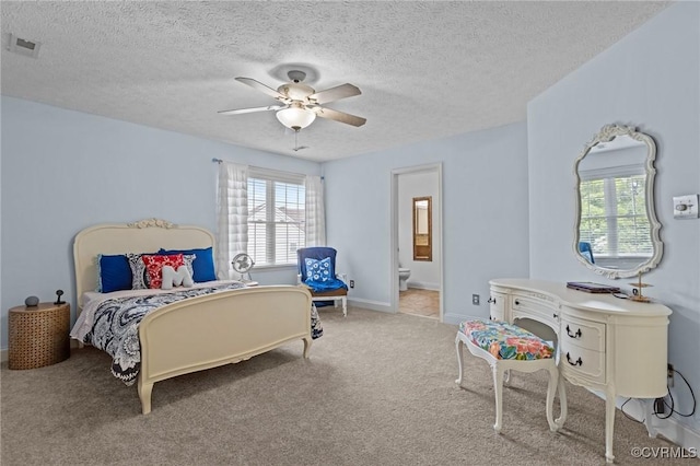 bedroom with ensuite bath, carpet floors, ceiling fan, visible vents, and a textured ceiling