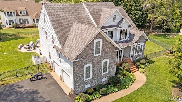 exterior space featuring a garage, an outdoor fire pit, aphalt driveway, and a yard