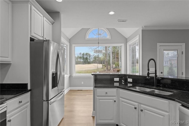 11421 Regal Ter, Providence Forge, VA 23140 - kitchen featuring appliances with stainless steel finishes, a sink, white cabinets, light wood-style floors, and vaulted ceiling