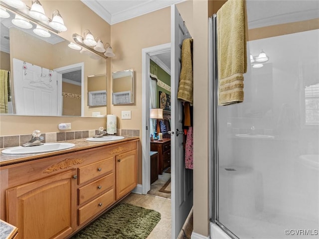 full bath featuring a shower stall, double vanity, ornamental molding, and a sink