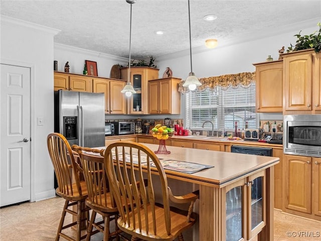 kitchen with crown molding, a center island, a sink, appliances with stainless steel finishes, and glass insert cabinets