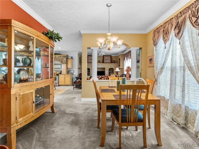 carpeted dining room with crown molding, an inviting chandelier, and ornate columns