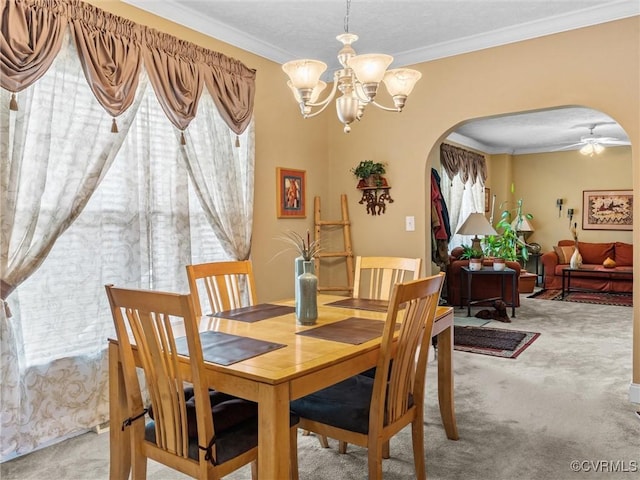 dining space with arched walkways, a notable chandelier, crown molding, and light carpet
