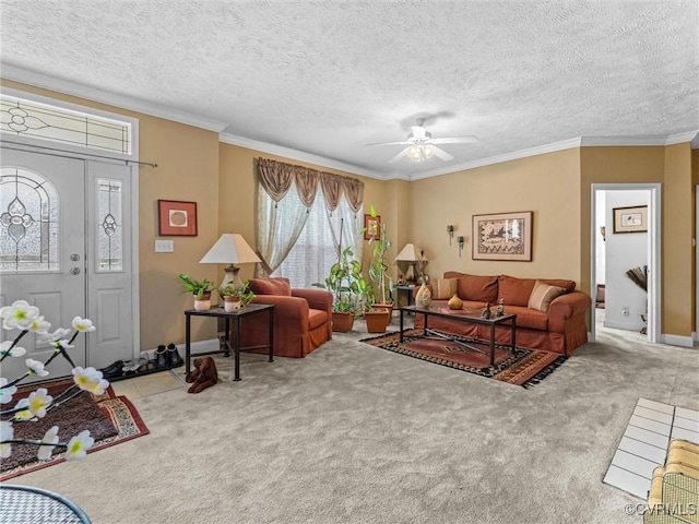 living area with crown molding, carpet floors, a textured ceiling, baseboards, and ceiling fan