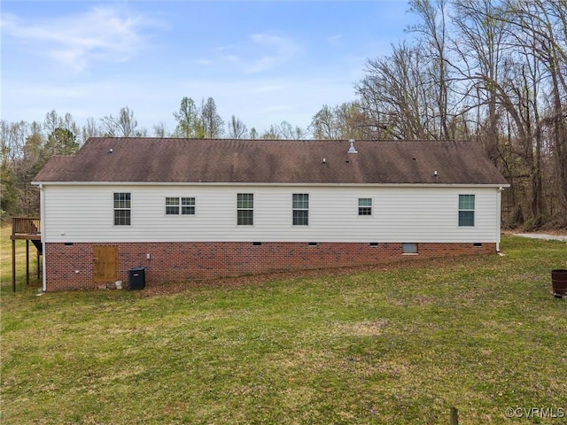 back of property featuring crawl space, central air condition unit, and a lawn