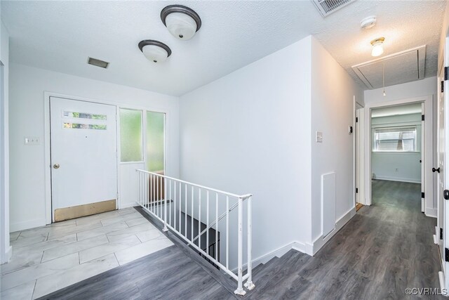 foyer entrance with visible vents, baseboards, and wood finished floors
