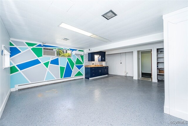 garage featuring baseboards, a wall mounted air conditioner, a wall mounted AC, and a baseboard radiator