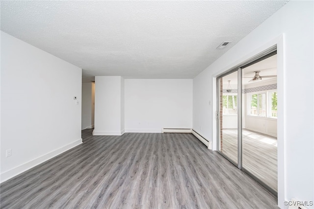 unfurnished living room featuring baseboards, a textured ceiling, visible vents, and wood finished floors