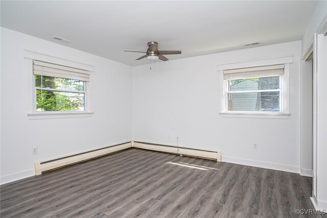 empty room with ceiling fan, visible vents, a wealth of natural light, and wood finished floors