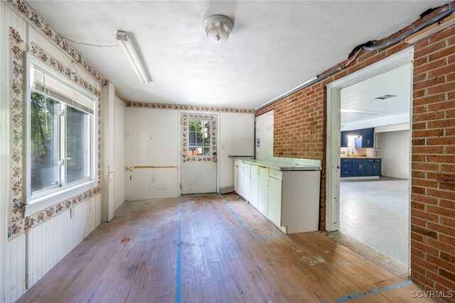 spare room with light wood-style floors and wallpapered walls