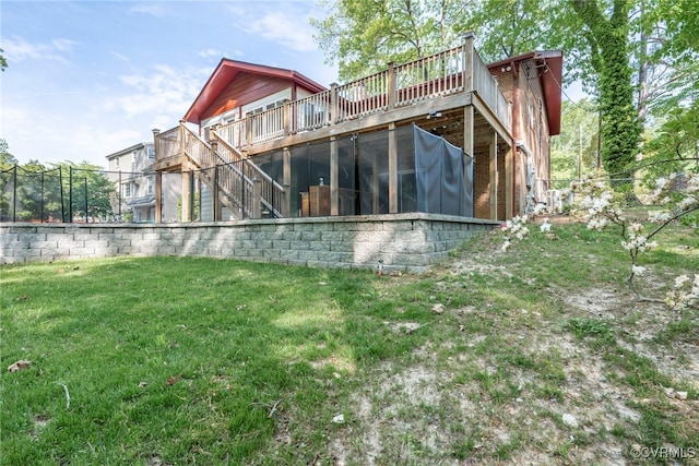 rear view of house featuring a lawn, stairway, and a deck
