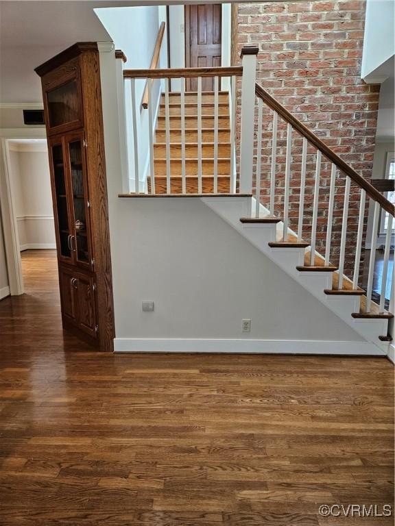 stairway featuring baseboards, visible vents, and wood finished floors