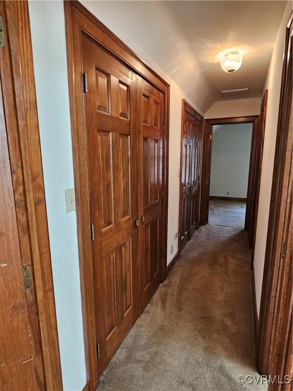 hallway with carpet flooring and lofted ceiling