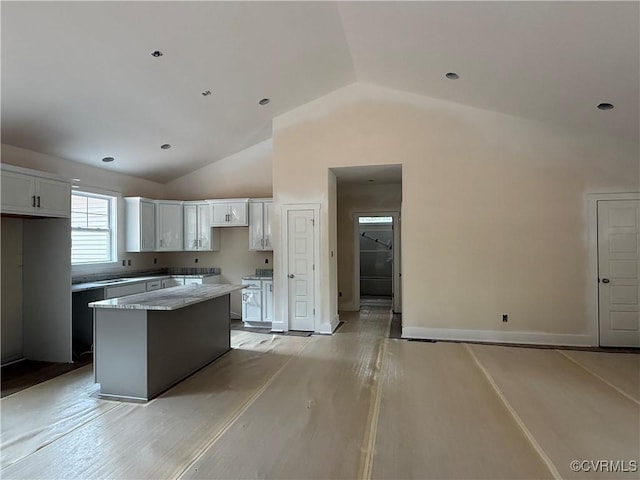 162 Tradewind Xing, Bracey, VA 23919 - kitchen featuring vaulted ceiling, a kitchen island, white cabinets, light wood-style flooring, and baseboards