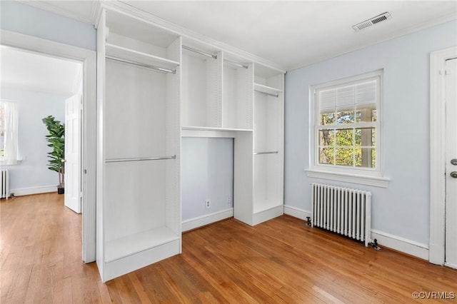 interior space featuring radiator, wood finished floors, and visible vents