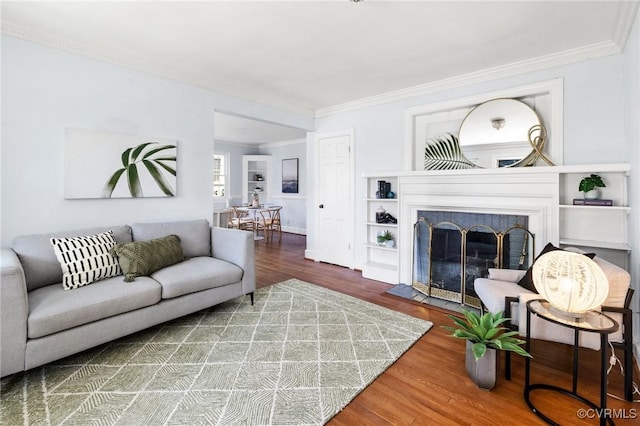 living area featuring a fireplace, ornamental molding, and wood finished floors
