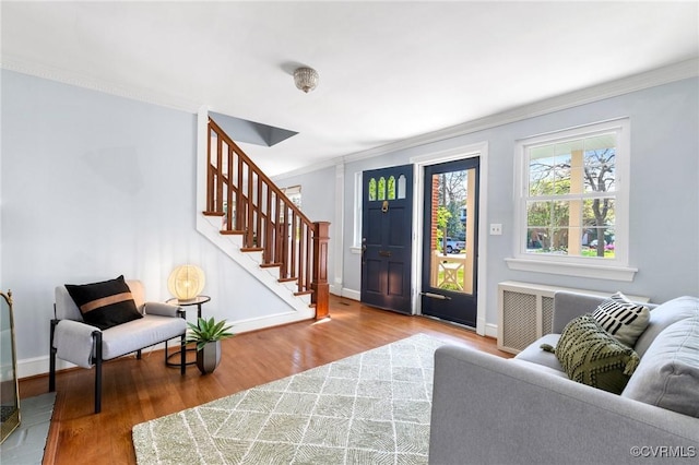 foyer entrance featuring stairway, baseboards, ornamental molding, and wood finished floors