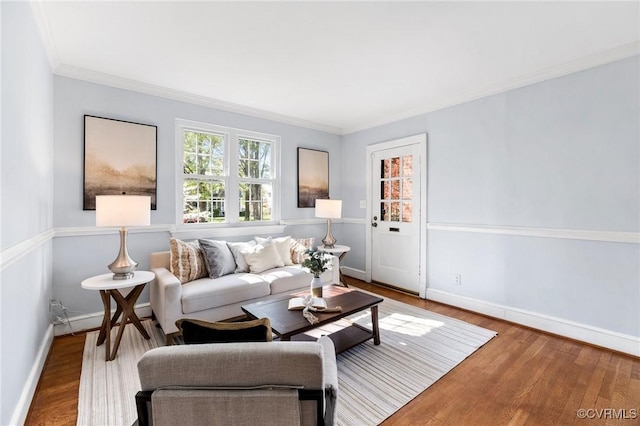 living area with crown molding, wood finished floors, and baseboards