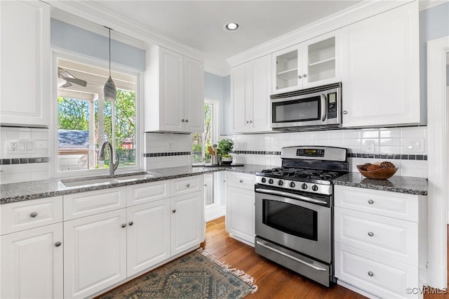 kitchen featuring glass insert cabinets, a sink, dark wood-style flooring, appliances with stainless steel finishes, and white cabinetry
