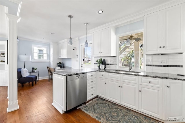 kitchen featuring a sink, a peninsula, white cabinetry, and dishwasher