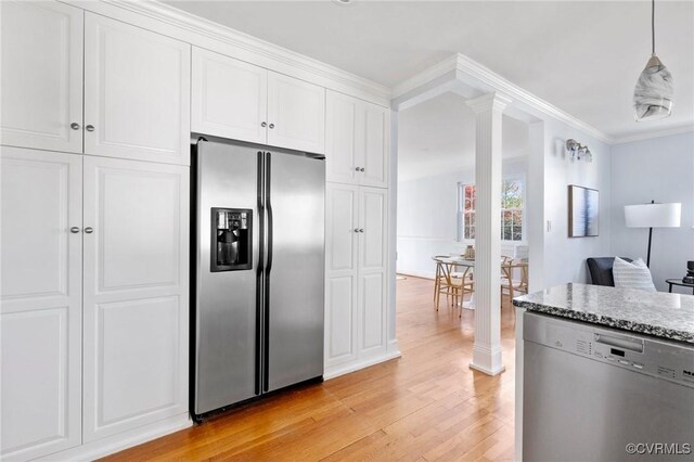 kitchen with light stone counters, white cabinets, light wood-style floors, ornate columns, and appliances with stainless steel finishes