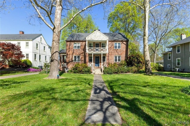 view of front facade featuring central AC unit, a front lawn, covered porch, and a balcony