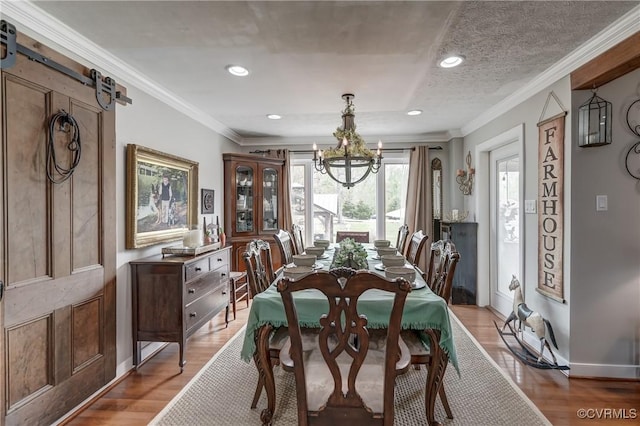 dining space featuring light wood-style flooring, an inviting chandelier, recessed lighting, and crown molding