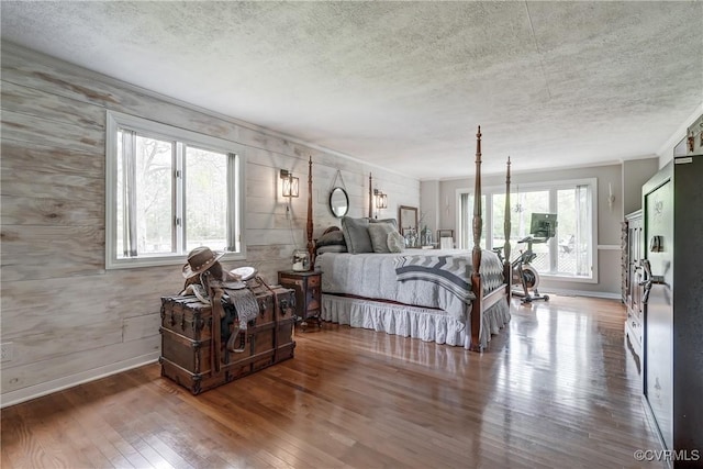 bedroom featuring baseboards, a textured ceiling, and hardwood / wood-style flooring
