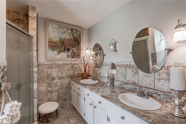 bathroom featuring tile walls, a sink, double vanity, and a stall shower